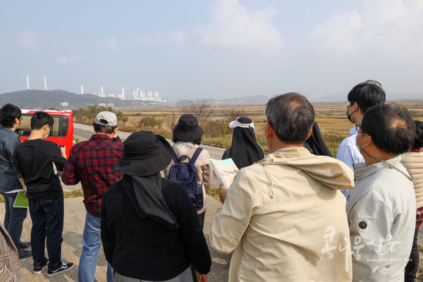 참가자들이 김병빈 당진발전본부 민간환경감시센터장과 함께 당진발전본부 일대를 돌아보고 있다. 멀리 당진화력발전소가 보인다.